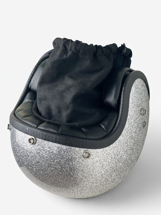 opening act. Maison Margiela Schultertasche in Form eines silbernen Glitzer-Helms mit schwarzem Stoffbeutel-Einsatz.