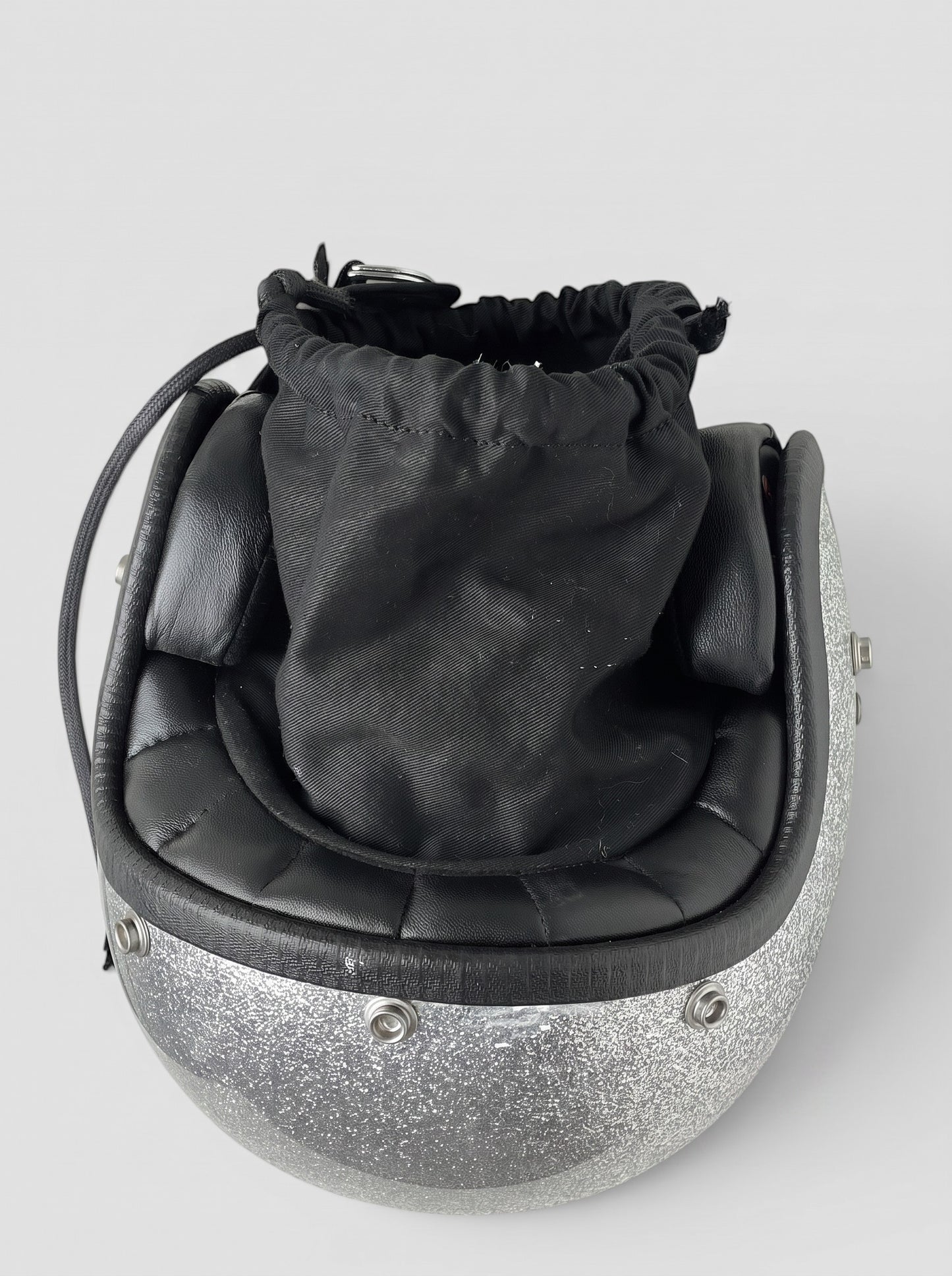opening act. Maison Margiela Schultertasche in Form eines silbernen Glitzer-Motorradhelms mit schwarzem Stoffbeutel