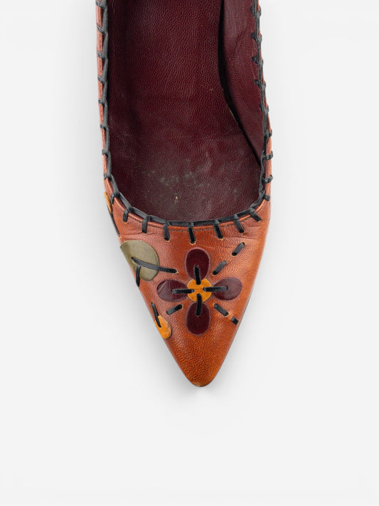 opening act. Prada AW99 Pumps aus dunkelbraunem Leder mit spitzer Zehenpartie, Blumenapplikationen und Ziernähten.